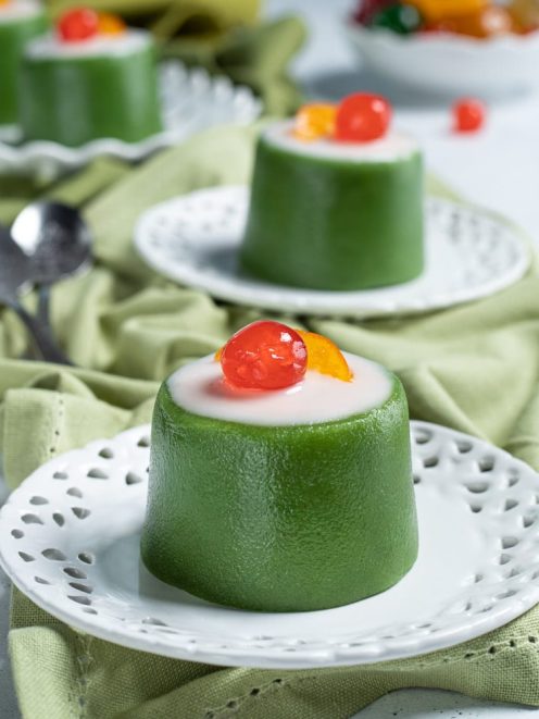 Tortino dolce alla cassata con involucro verde, glassa bianca e ciliegia candita in cima