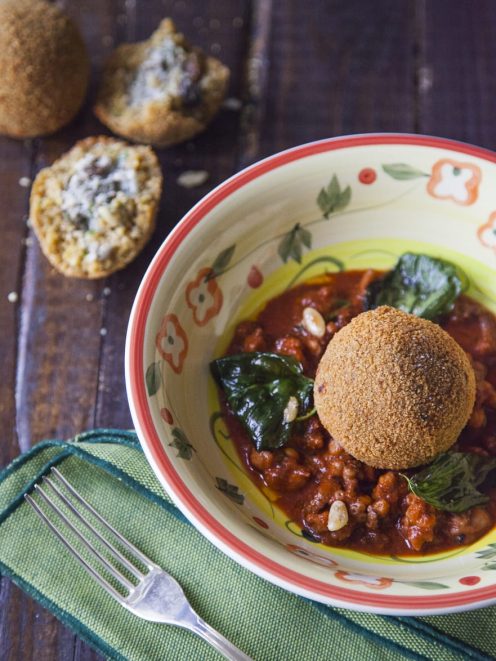 Arancini di couscous con sarde adagiati su ragù di pomodoro con foglie di basilico fritto