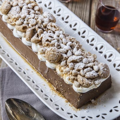 Budino al cioccolato con rum e amaretti guarnito con panna e zucchero a velo