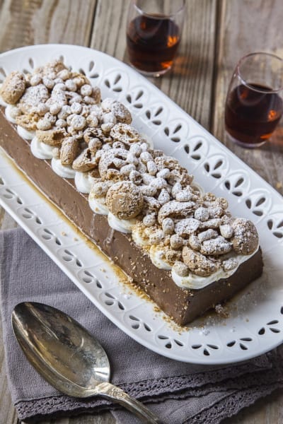Budino al cioccolato con rum e amaretti guarnito con panna e zucchero a velo