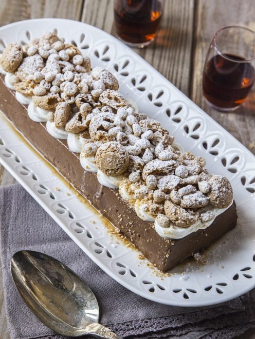 Budino al cioccolato con rum e amaretti guarnito con panna e zucchero a velo