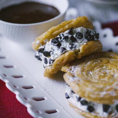 Churros sandwich farciti con crema di ricotta e gocce di cioccolato, spolverati di zucchero a velo