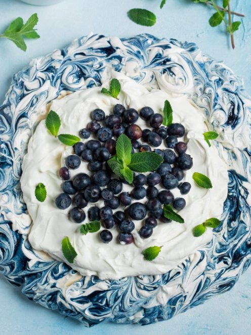 Blueberry Pavlova con meringa marmorizzata, panna montata, mirtilli freschi e foglioline di menta