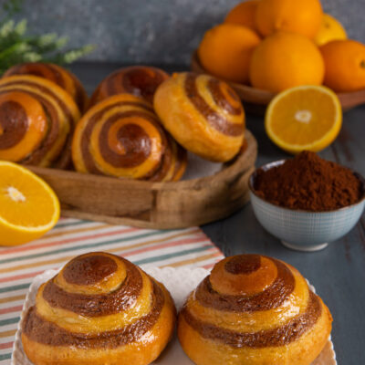 Brioche vortice dorate con spirale bicolore all'arancia e cacao, lucide in superficie