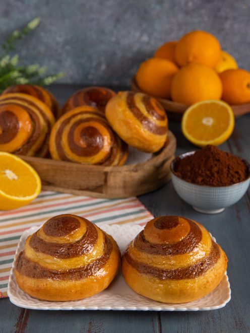 Brioche vortice dorate con spirale bicolore all'arancia e cacao, lucide in superficie