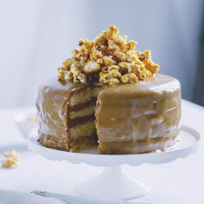 Caramel cake a strati glassata al caramello, guarnita con popcorn caramellati in cima