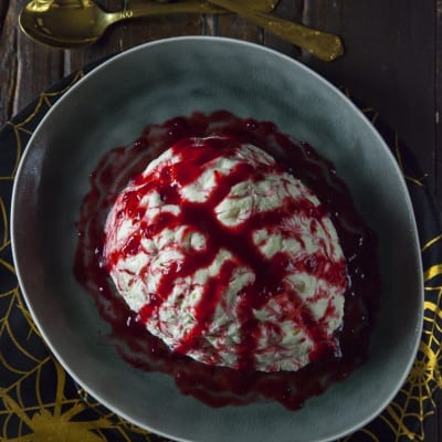 Cervello di Halloween a forma di semisfera solcata, ricoperto di salsa ai frutti di bosco color sangue