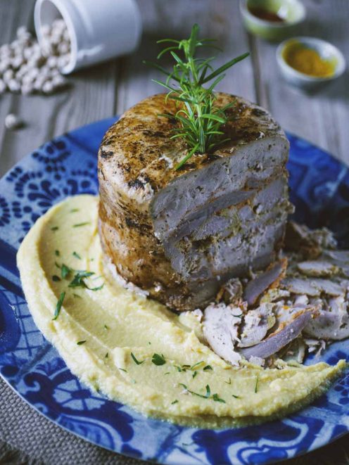 Kebab arrosto su letto di hummus cremoso, guarnito con un rametto di rosmarino fresco
