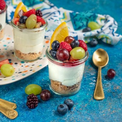 Mousse di yogurt e frutta in bicchiere con base di biscotto, crema soffice e frutti di bosco misti