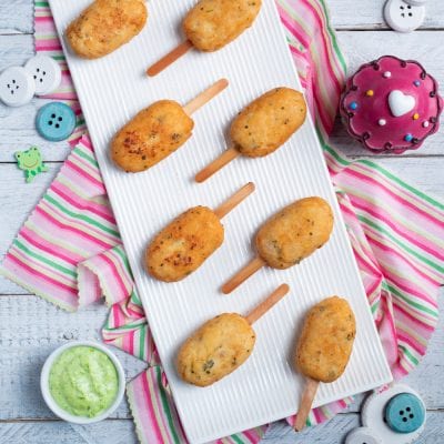 Polpette su stecco dorate e croccanti, servite con salsa verde