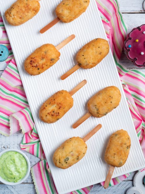 Polpette su stecco dorate e croccanti, servite con salsa verde