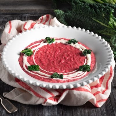 Risotto alla barbabietola con crema bianca a spirale e foglie di cavolo nero croccanti