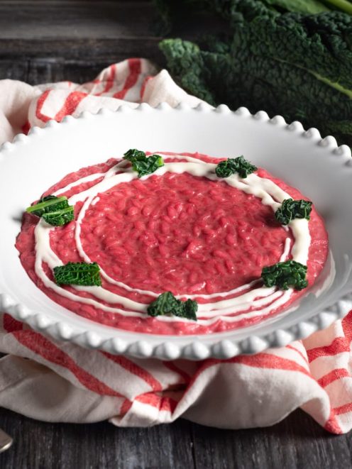 Risotto alla barbabietola con crema bianca a spirale e foglie di cavolo nero croccanti
