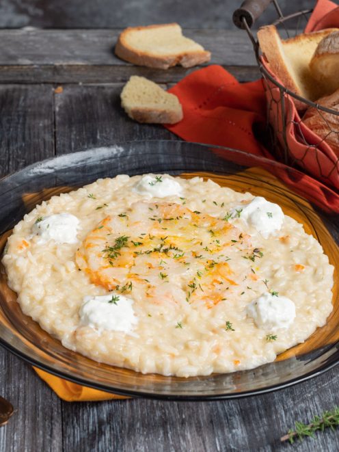 Risotto con crudo di gamberi mantecato, guarnito con quenelle di formaggio fresco e timo