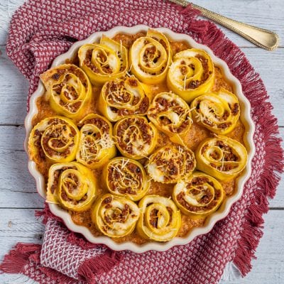 Roselline di lasagne al forno farcite di ragù, gratinate con formaggio filante in teglia rotonda
