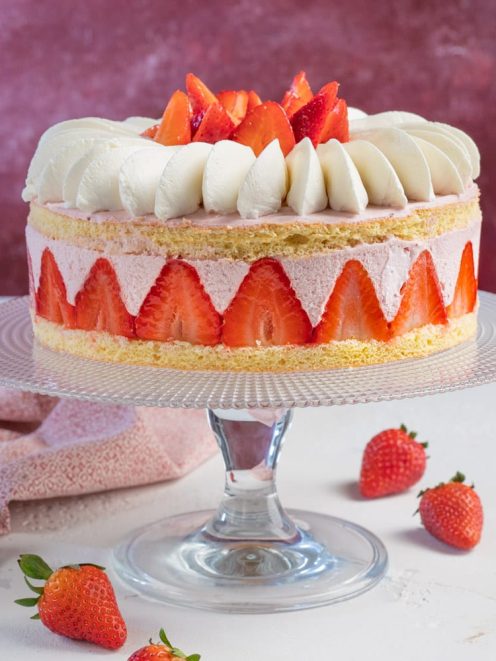 Torta con mousse di fragole con pan di spagna, crema alla fragola e fragole fresche a spicchi