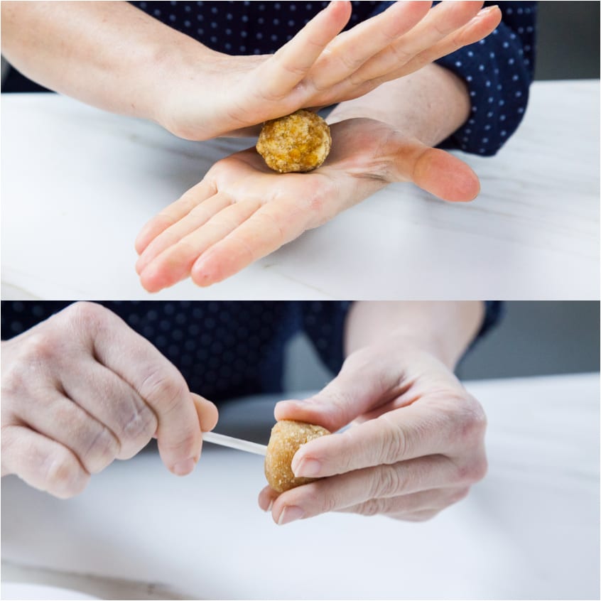 Mani che modellano un cake pop a sfera e infilano il bastoncino alla base