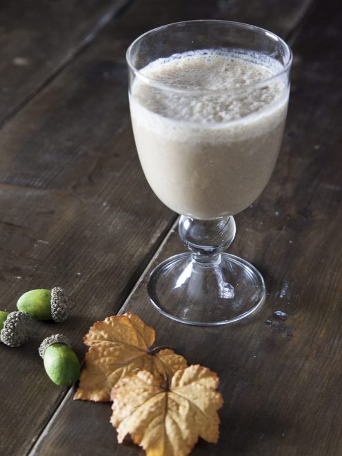 Smoothie di banana, carruba e latte di nocciole servito in calice con superficie schiumosa
