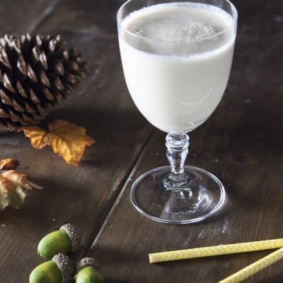 Smoothie di pera, caramello e latte vegetale servito in calice con superficie spumosa
