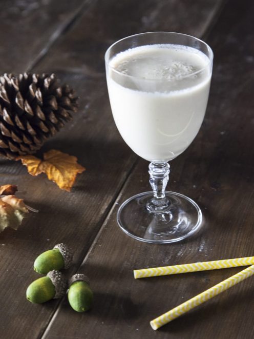 Smoothie di pera, caramello e latte vegetale servito in calice con superficie spumosa