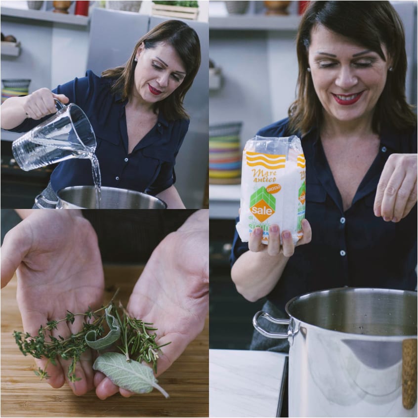 Una cuoca versa acqua in pentola, aggiunge sale grosso e tiene in mano erbe aromatiche fresche