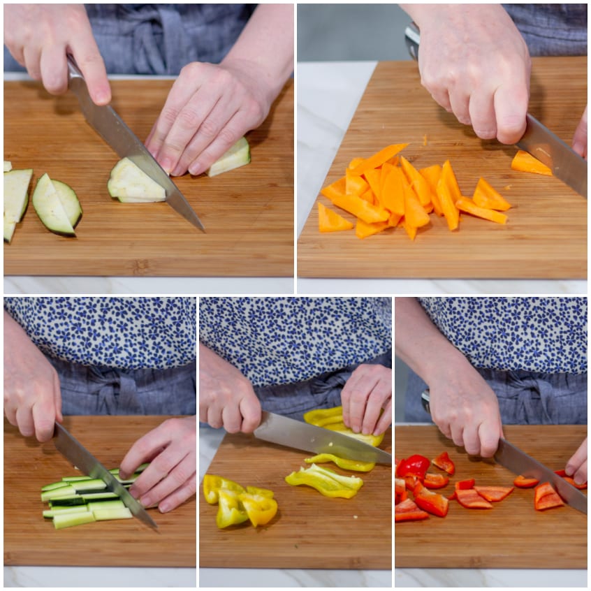 Mani che tagliano a losanghe zucchine, carote e peperoni colorati sul tagliere