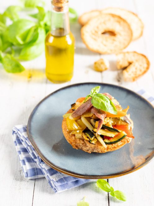 Frisella con caponata di verdure, zucchine, peperoni e foglia di basilico fresco