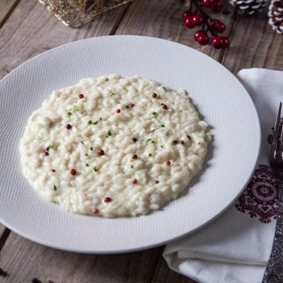 Risotto al mascarpone e pepe rosa mantecato, guarnito con grani di pepe rosa e erba cipollina tritata