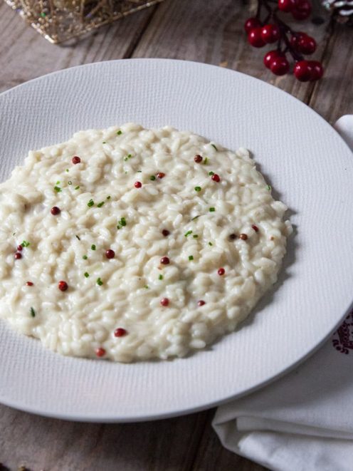 Risotto al mascarpone e pepe rosa mantecato, guarnito con grani di pepe rosa e erba cipollina tritata
