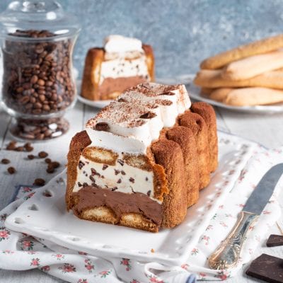 Stracchino della duchessa a fette con strati di crema al cioccolato, mascarpone e savoiardi spolverati di cacao