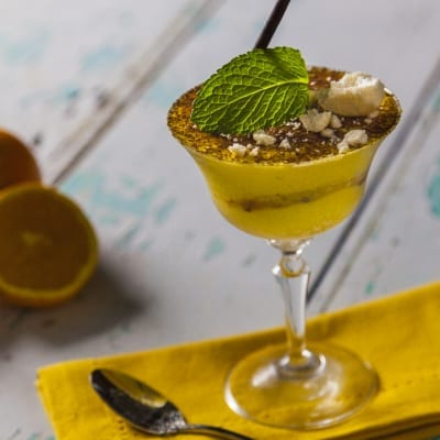 Coppa di pandoro con crema all'arancia, cacao in polvere, briciole e foglia di menta fresca