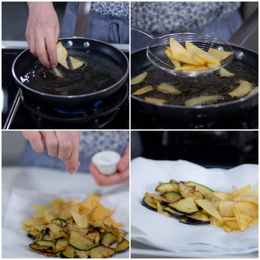 Fette di patate e melanzane fritte in olio bollente, scolate e salate su carta assorbente