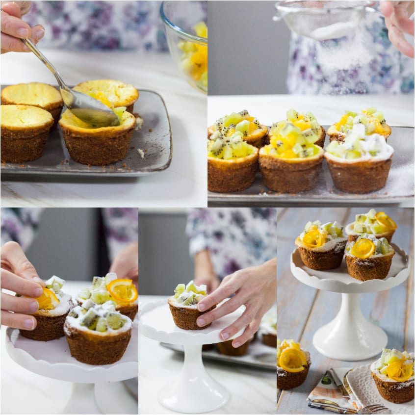 Mani che decorano le mini cheesecake con kiwi, arancia e una spolverata di zucchero a velo