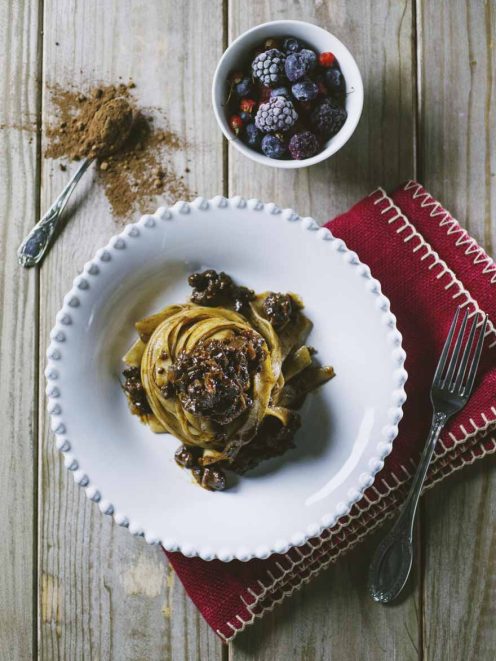 Tagliatelle al ragù di anatra, cacao e frutti rossi servite a nido con salsa scura e bacche