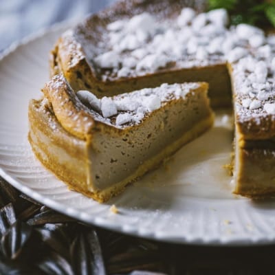 Torta Earl Grey con crosta dorata, ripieno cremoso e zucchero a velo, servita con una fetta estratta