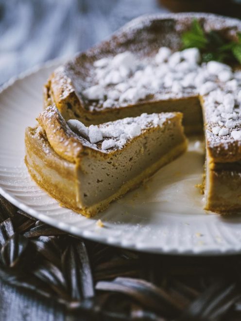 Torta Earl Grey con crosta dorata, ripieno cremoso e zucchero a velo, servita con una fetta estratta