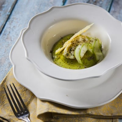 Uovo poché con asparagi su crema verde, guarnito con scaglie di formaggio e zucchine a julienne