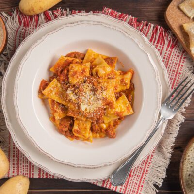 Agnolotti ripieni di patate e pecorino con sugo di pomodoro e formaggio grattugiato