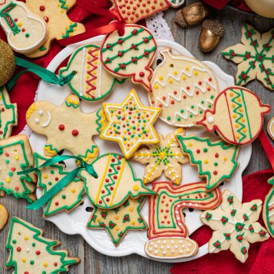 Biscotti di Natale decorati con glassa colorata a forme di stelle, alberelli e palline