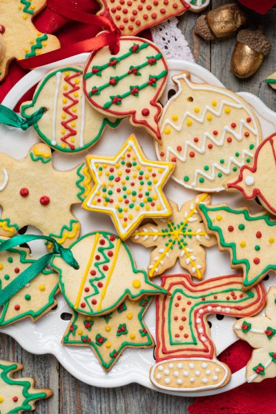 Biscotti di Natale decorati con glassa colorata a forme di stelle, alberelli e palline