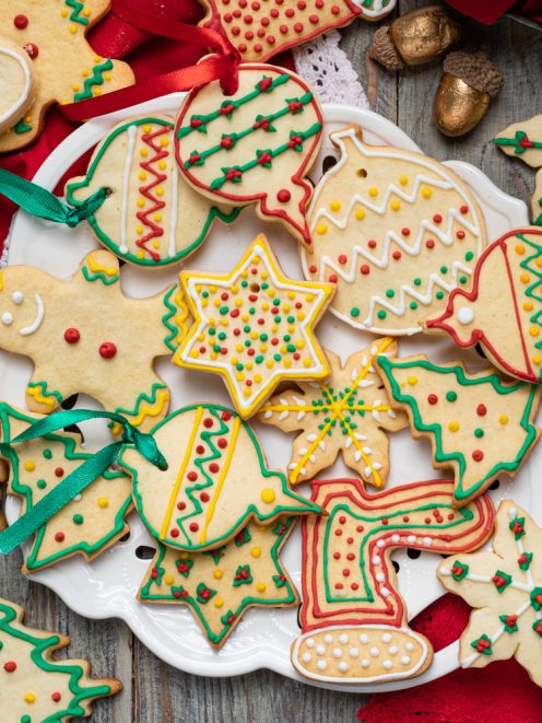 Biscotti di Natale decorati con glassa colorata a forme di stelle, alberelli e palline