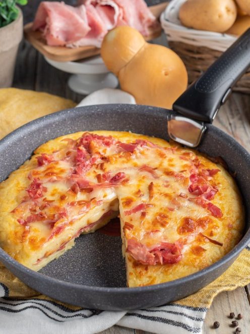 Focaccia in padella con prosciutto cotto e formaggio filante, una fetta già tagliata