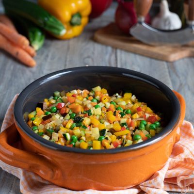 Ragù di verdure con piselli, zucchine, carote e peperoni a dadini saltati insieme