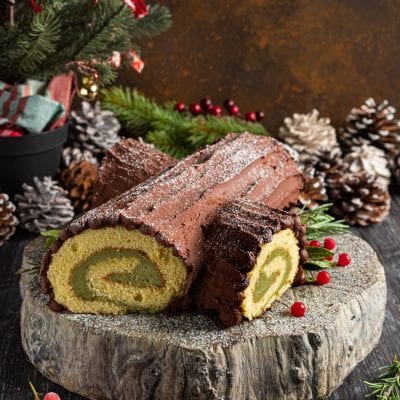 Tronchetto di Natale al cioccolato con farcitura al matcha, affettato per mostrare la spirale interna