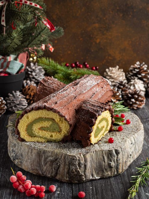 Tronchetto di Natale al cioccolato con farcitura al matcha, affettato per mostrare la spirale interna