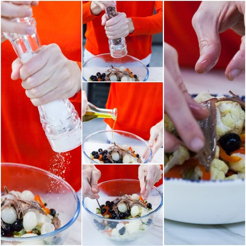 Condimento dell'insalata di rinforzo con sale, pepe e olio, poi acciughe intere per decorare