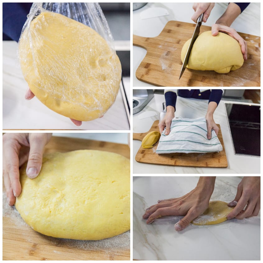 Impasto per pasta fresca diviso in porzioni: una avvolta nella pellicola, una tagliata a coltello e una stesa a mano sul piano infarinato