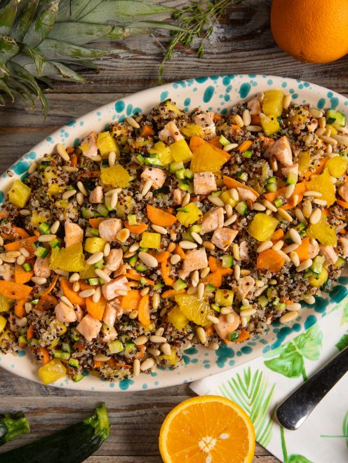 Insalata di quinoa con salmone, carote, zucchine, ananas, arancia e pinoli tostati