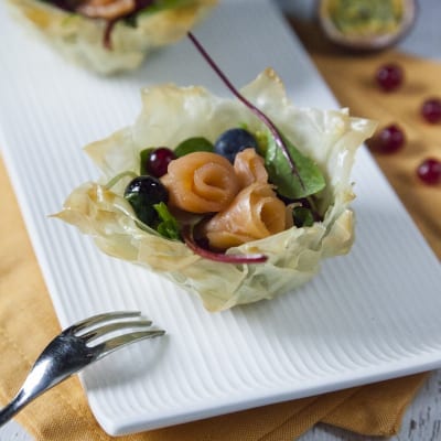 Cestini di pasta fillo con roselline di salmone affumicato, mirtilli, ribes e insalata mista