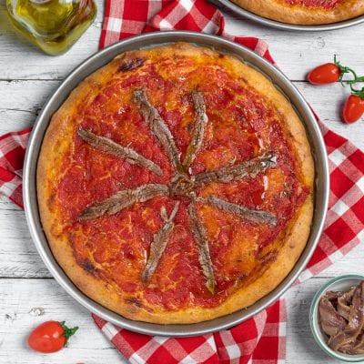 Focaccia integrale alla marinara con salsa di pomodoro e acciughe disposte a raggiera